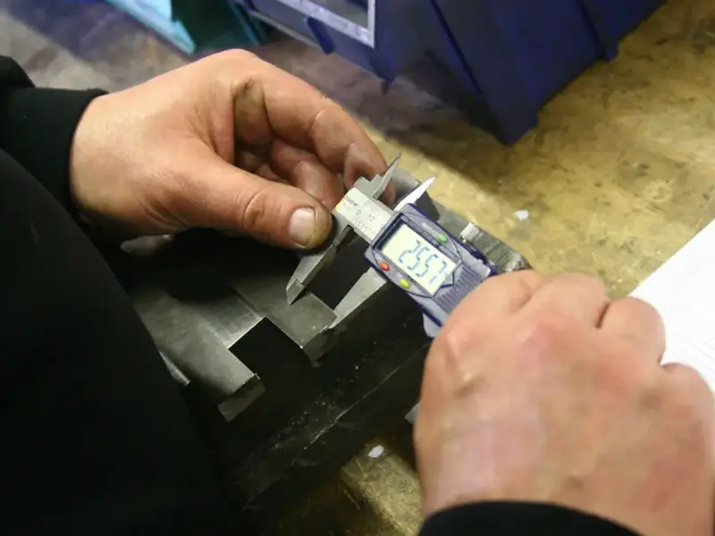 Measuring a metal part with a digital caliper